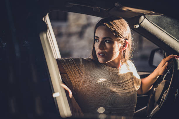 istock Young beautiful woman parking her car in reverse. 1199607779