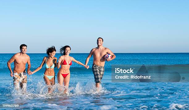 Photo libre de droit de Sourire Des Amis À Jouer À La Plage banque d'images et plus d'images libres de droit de Adolescent - Adolescent, Adulte, Amitié