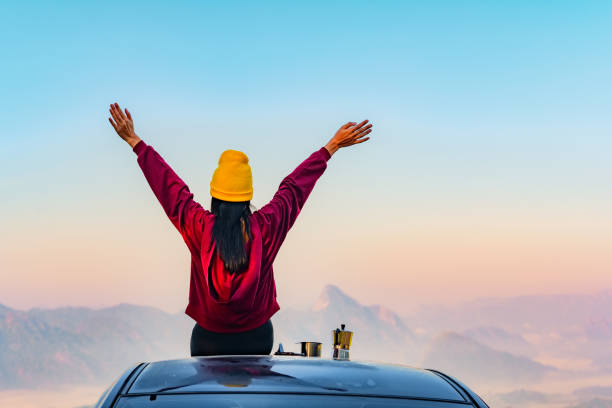 Trip 5 Woman traveller enjoy coffee time on her owns roof of the car with scenery view of the mountain and mist morning in background happy car asian stock pictures, royalty-free photos & images