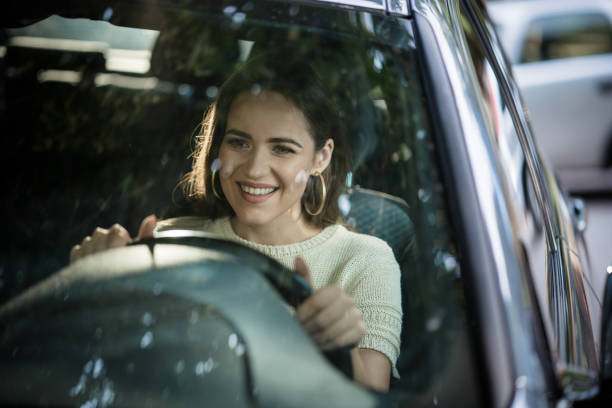 istock Young happy woman driving a car. 1199608656