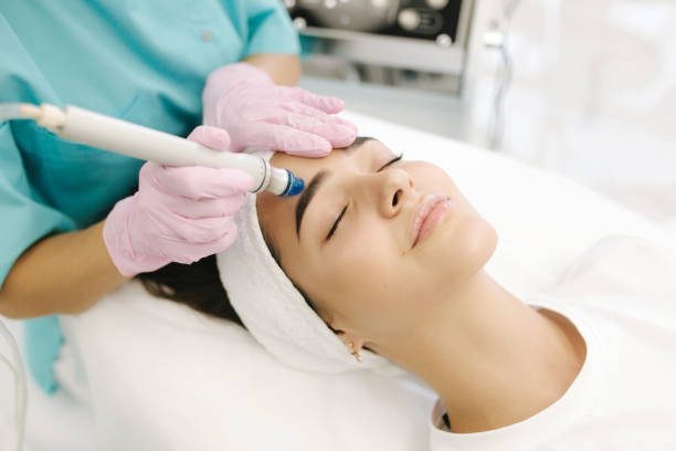 Close-up of woman getting facial hydro microdermabrasion peeling treatment. Female at cosmetic beauty spa slinic. Hydra vacuum cleaner. Cosmetology stock photo