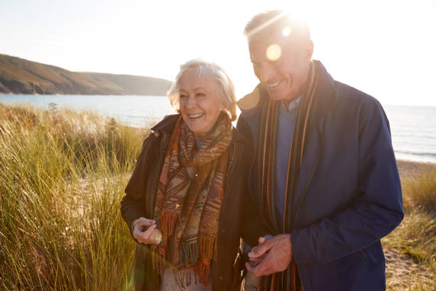 istock Loving Active Senior Couple Arm In Arm Walking Through Sand Dunes 1199612028