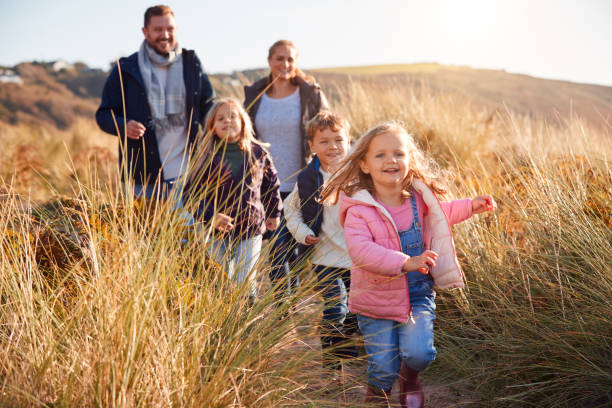 rodzina idąca wzdłuż ścieżki przez wydmy razem - family winter walking fun zdjęcia i obrazy z banku zdjęć