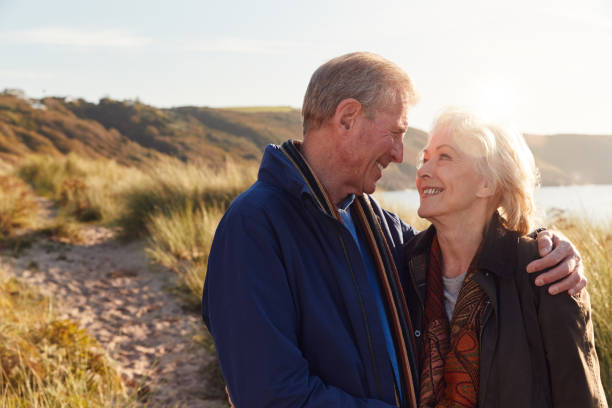 istock Loving Active Senior Couple Hugging As They Walk Through Sand Dunes 1199612653
