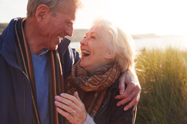 istock Loving Active Senior Couple Hugging As They Walk Through Sand Dunes 1199612670