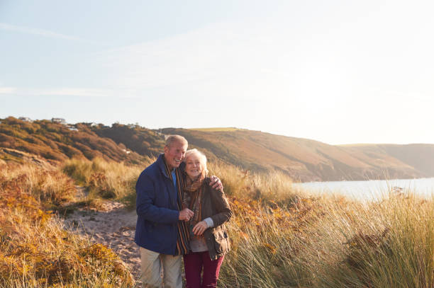 istock Loving Active Senior Couple Hugging As They Walk Through Sand Dunes 1199612699