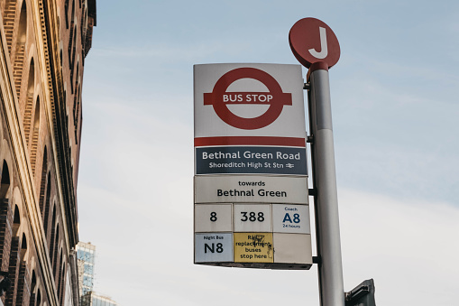 London, UK - Aug 14, 2023: Iconic, classic red double decker bus driving, turning on intersection with people sitting, eating during Afternoon Tea Tour