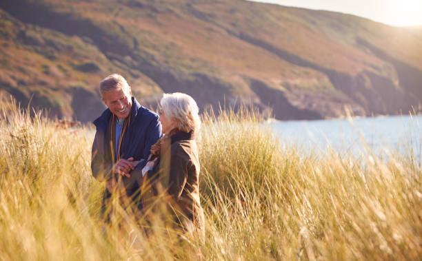 istock Loving Active Senior Couple Arm In Arm Walking Through Sand Dunes 1199613899
