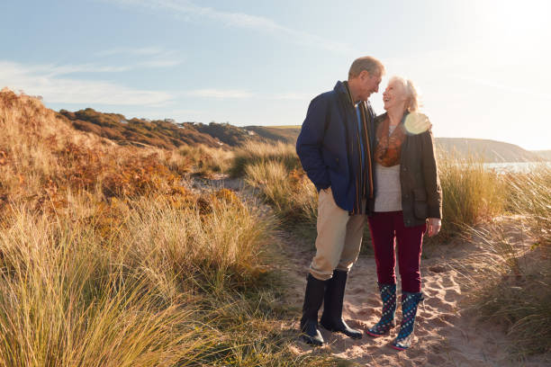 istock Loving Active Senior Couple Hugging As They Walk Through Sand Dunes 1199613900