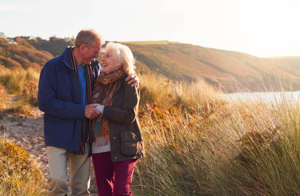 istock Loving Active Senior Couple Hugging As They Walk Through Sand Dunes 1199615343