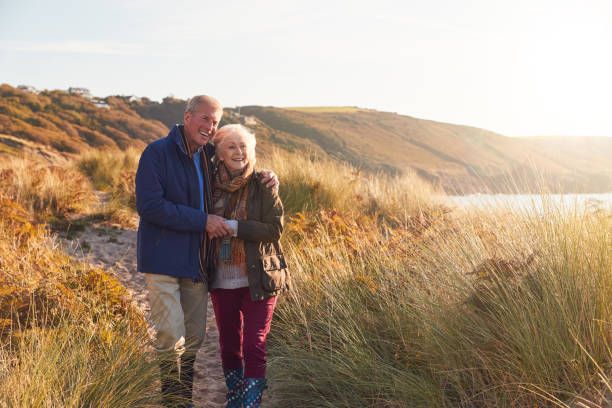 istock Loving Active Senior Couple Hugging As They Walk Through Sand Dunes 1199615539