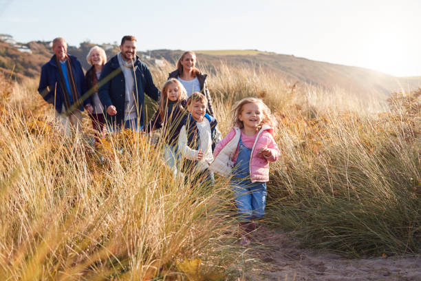 istock Multi-Generation Family Walking Along Path Through Sand Dunes Together 1199615654