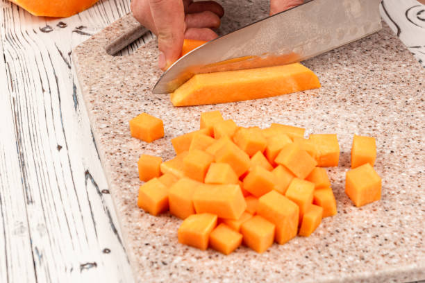 istock Slicing pumpkin on a cutting kitchen board made of artificial stone 1199615680