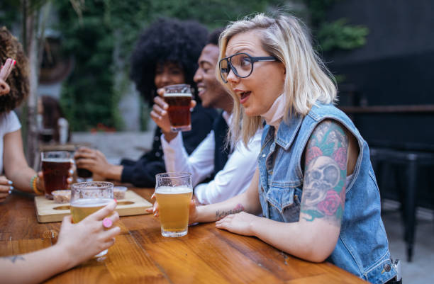 istock Group of friends drinking beer outdoors in pub 1199617235