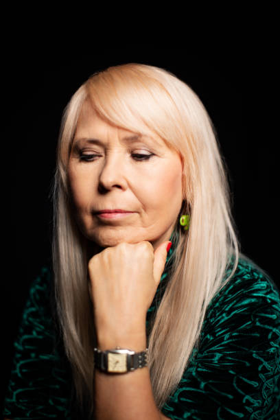 istock Thoughtful senior woman on black background 1199617839