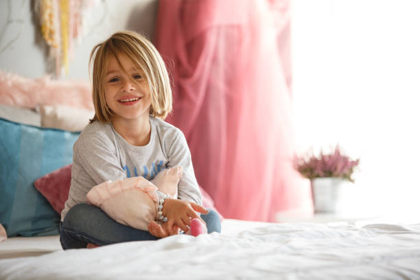 istock Girl with heart shaped pillow looking at camera 1199619104