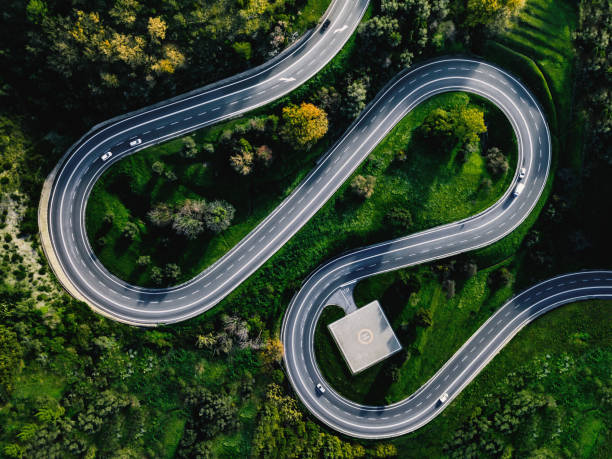 aerial view of winding curved road with helicopter parking in italy - road winding road highway mountain imagens e fotografias de stock