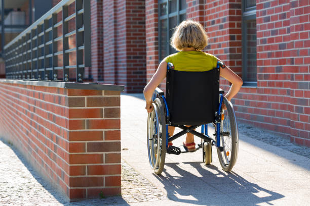 woman on wheelchair entering the platform stock photo