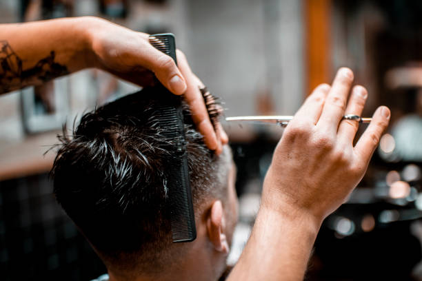 istock A barber cutting a man's hair in a barber salon 1199620949