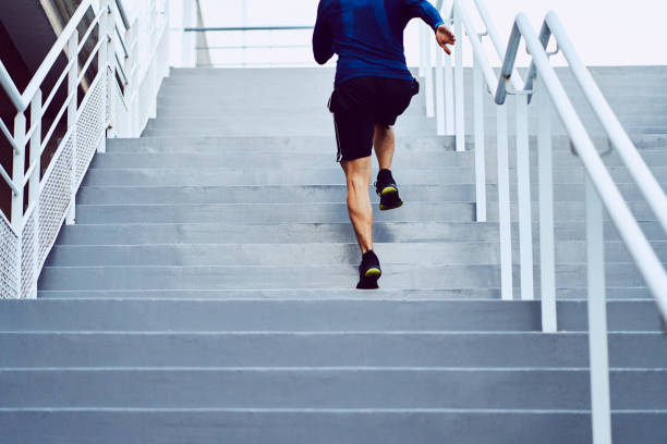 フィットネス、健康、スポーツのコンセプト。2階を走るアスレチックマン - outdoors exercising climbing motivation ストックフォトと画像