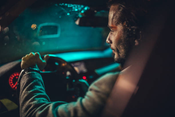 istock Businessman Driving A Car In Night 1199622331