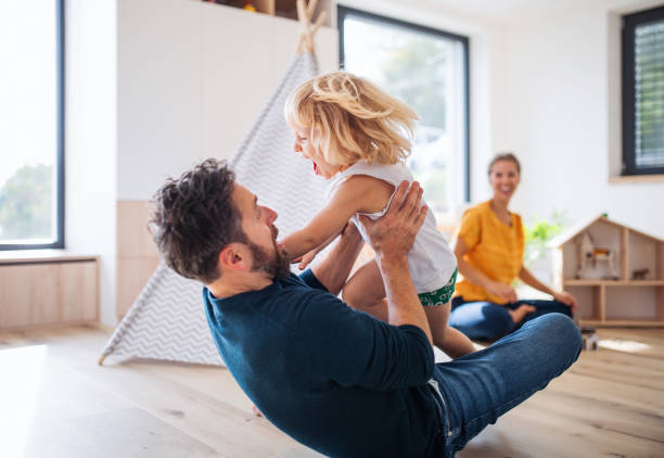 giovane famiglia con bambino piccolo al chiuso in camera da letto che si diverte. - fun time foto e immagini stock