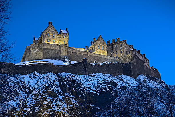 schloss edinburgh, schottland, uk, beleuchtet bei sonnenuntergang mit winter snow - castle rock stock-fotos und bilder