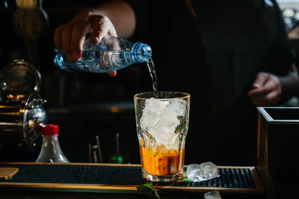 istock hand bartender make cocktail. Cocktail have orange and mint leaves. 1199623243