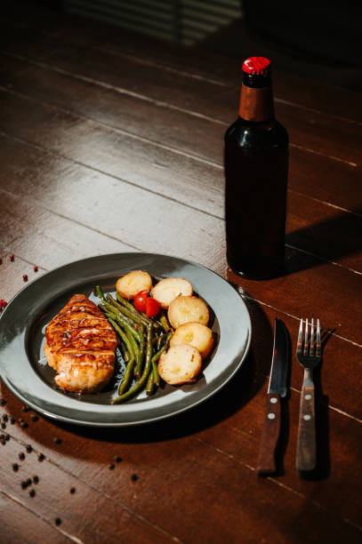 Steak with fried potatoes and green beans in a white plate