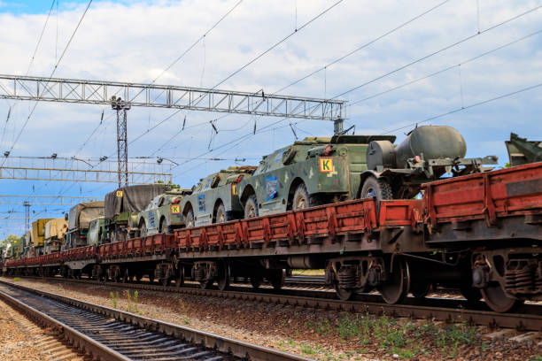 istock Cargo train carrying military vehicles on railway flat wagons 1199624475