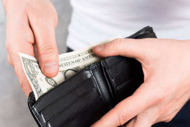 istock Young man gets cash from leather wallet. 1199624494