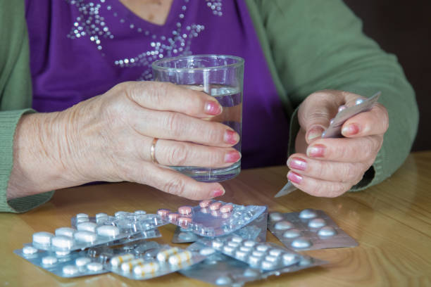 istock senior woman's hands with pills and medications 1199624751