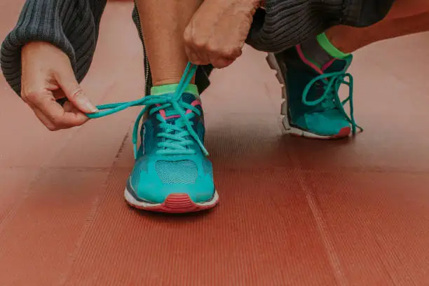 Photo of closeup of hands tying the running shoe