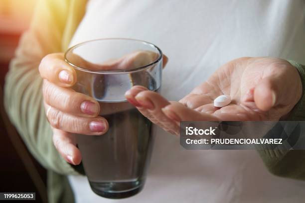 Senior Hand With Pills And Glass Of Water Stock Photo - Download Image Now - Active Seniors, Adult, Aging Process