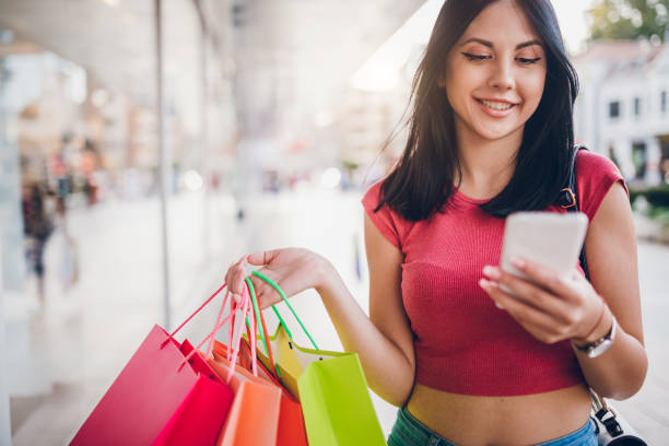istock Using phone with shopping bags 1199628160