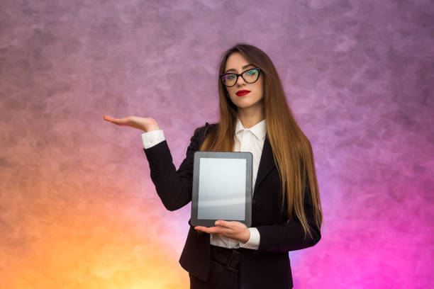 istock Cute woman in glasses using tablet on abstract background. Business concept 1199632582