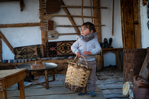 Boy carrying baskets in the village house