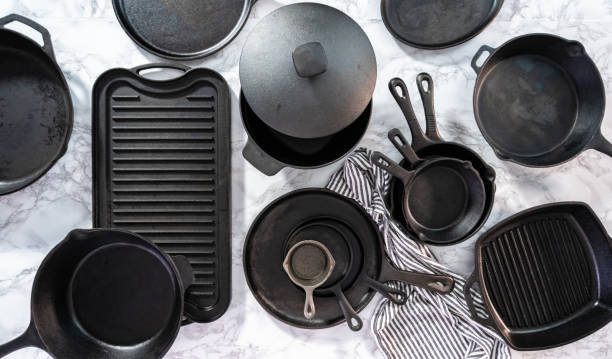 Variety of cast iron frying pans on a marble background. stock photo