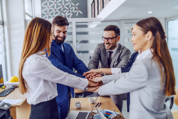 istock Five dedicated hardworking colleagues standing in boardroom and stacking hands. teamwork concept. 1199638612