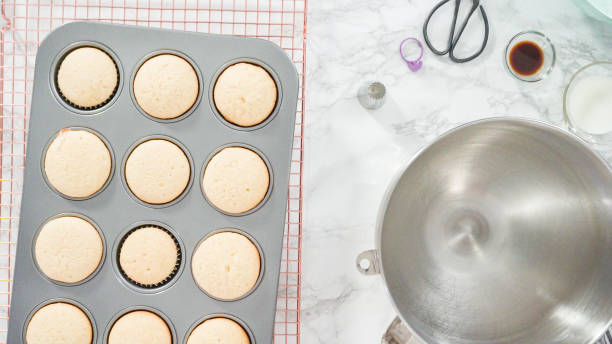 istock Cooling freshly baked vanilla cupcakes on wire cooling rack. 1199639421