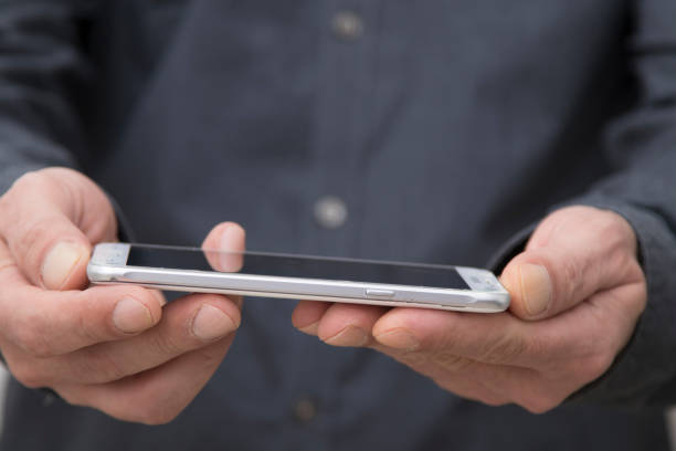 istock businessman hands with mobile touch phone, closeup view 1199639542