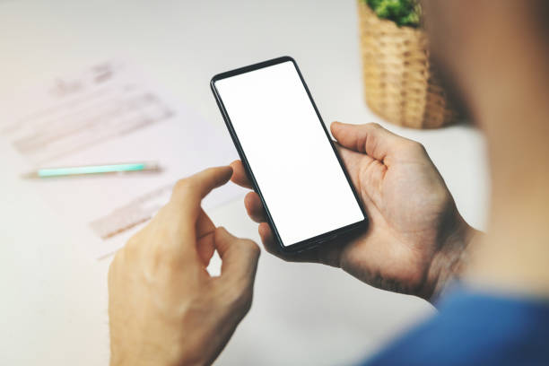 istock man using smartphone for financial transactions. holding phone with blank screen in hand 1199639626