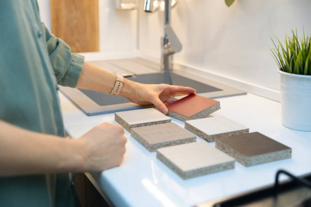 mujer eligiendo la textura del material de la encimera de la cocina de las muestras - plástico laminado fotografías e imágenes de stock