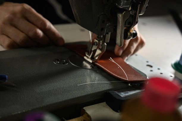 istock Working process of leather craftsman. Tanner or skinner sews leather on a special sewing machine, close up. 1199640144