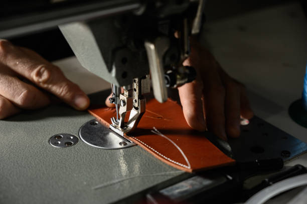 istock Working process of leather craftsman. Tanner or skinner sews leather on a special sewing machine, close up. 1199640156