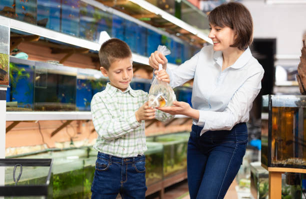 istock Woman with son holding plastic bag with fish 1199640528
