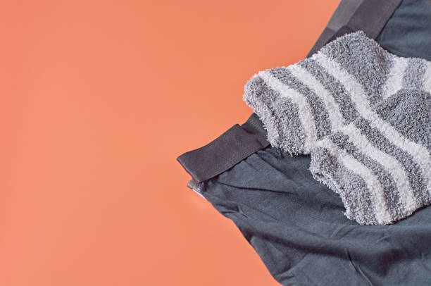 istock Striped soft and warm socks and new dark underpants on orange background. Space for text. 1199641768