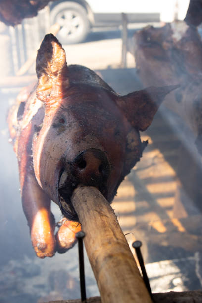 arrostimento di maiale allo spiedo - spit roasted barbecue grill barbecue pork foto e immagini stock