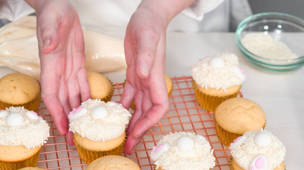 istock Decorating vanilla cupcakes with white buttercream frosting for Easter. 1199644259