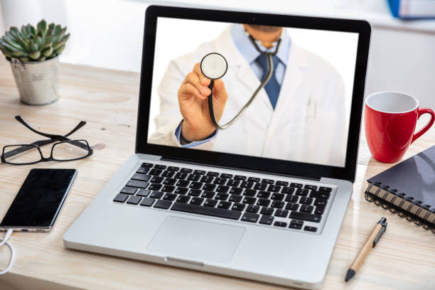 istock Telemedicine concept. Doctor GP on a computer screen, office desk background 1199644395